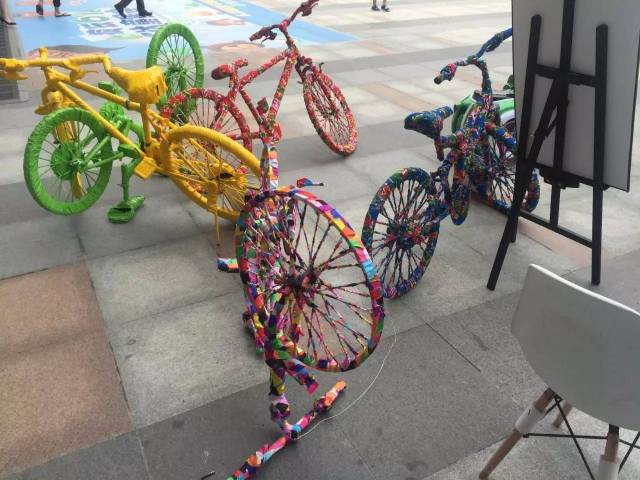 废旧自行车通过彩色布料的缠绕,变成了具有视觉趣味的艺术装置.