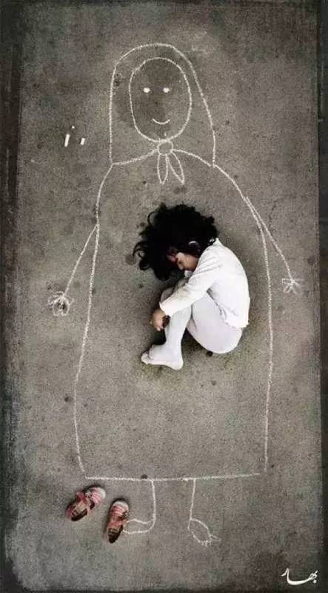 伊拉克战争失去妈妈的小女孩,在地上画上了妈妈.