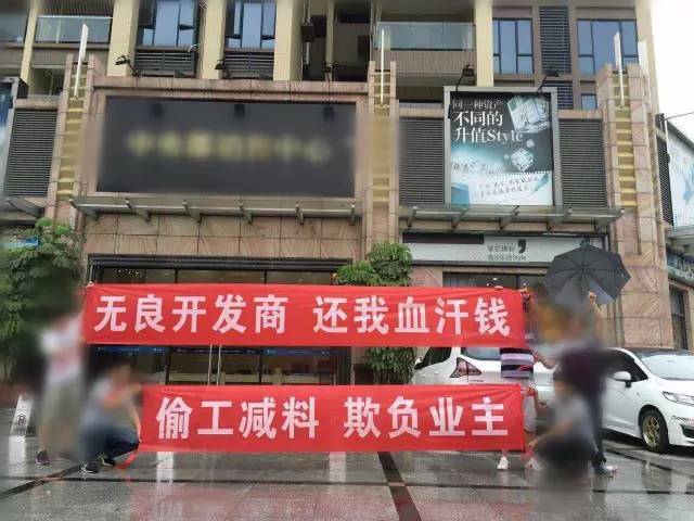 这群街坊在南沙某小区门口拉横幅维权,打出"无良开发商 还我血汗钱"