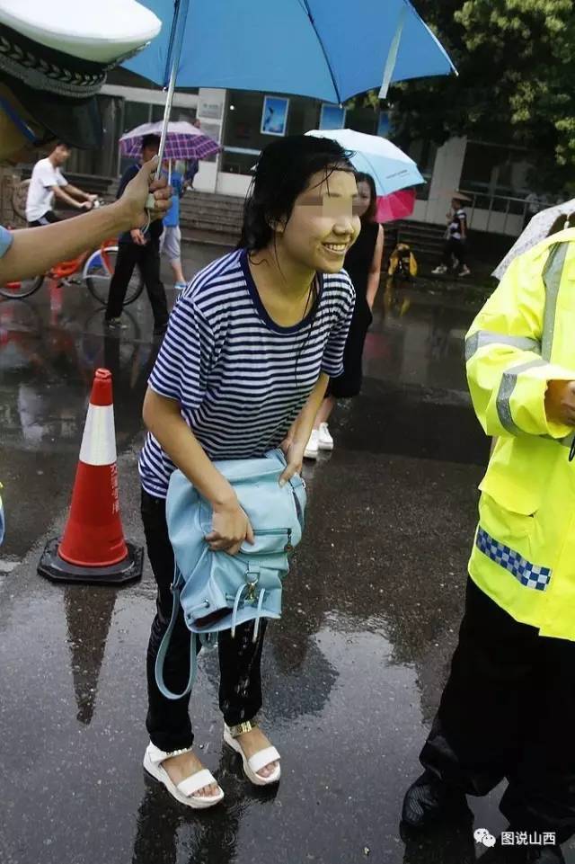 女孩浑身湿透,连惊带吓浑身在瑟瑟发抖,交警为其撑起了雨伞