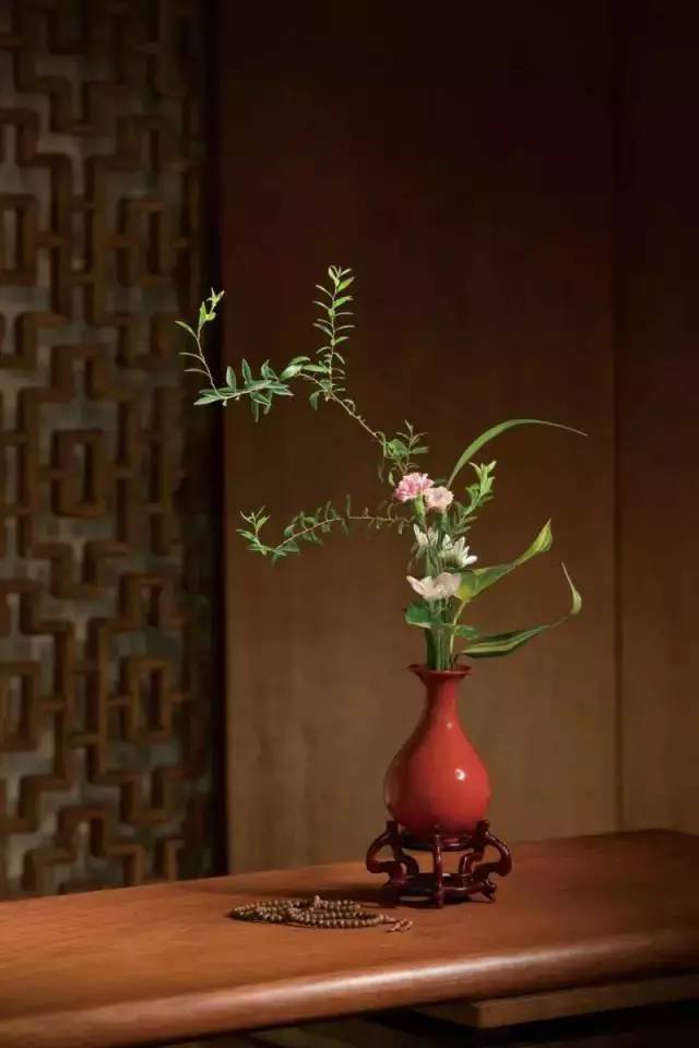 悬崖式是指第一主枝在花器上悬挂而下为造型特征的插花;平卧式
