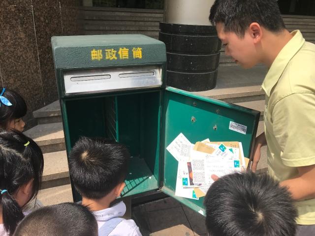 活动开始,孩子们观察了大邮筒,填单台,电子秤,在邮政局工作人员的