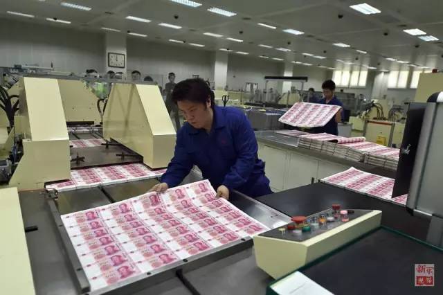 北钞公司工作人员将印制完成的大张新版百元钞票摆放在机器上进行