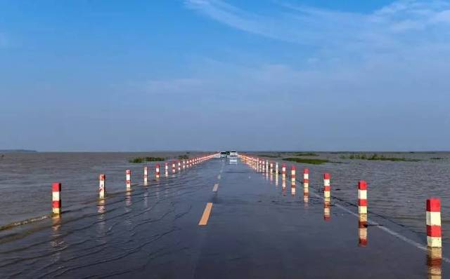 每年暑期,雨水丰沛 鄱阳湖的水位上涨 永吴公路大湖池路面就会被淹没