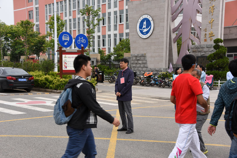 洪泽中学校长李建成站在门口迎着学生进场