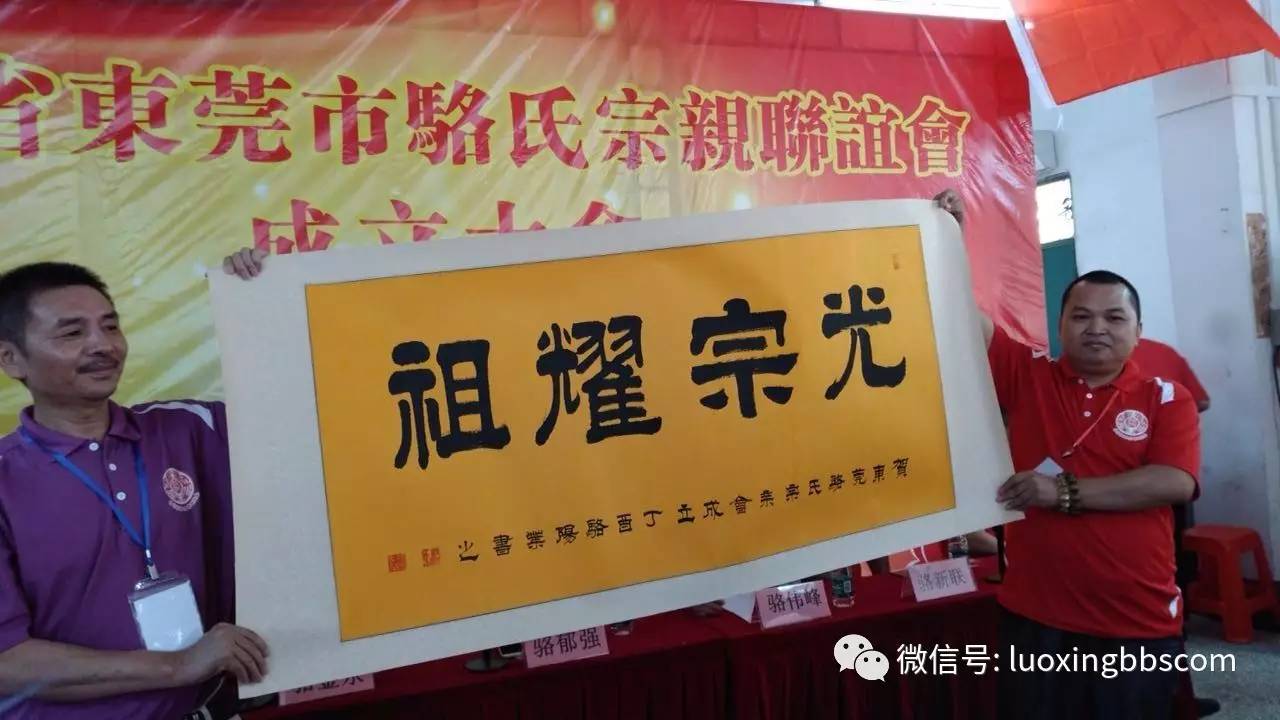 丹霞书画院院长骆阳叶(左),在成立大会现场赠送书法作品《光宗耀祖》