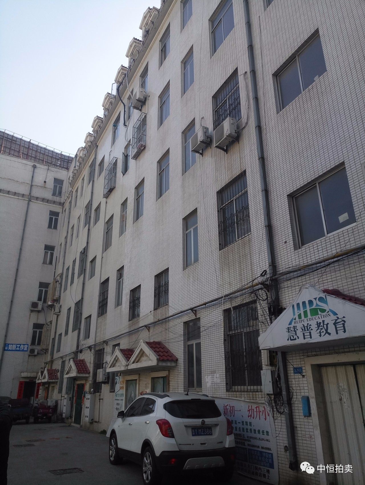 该房屋建筑物位于龙口市黄城北巷小区院内,东临东莱街商住楼,西邻博