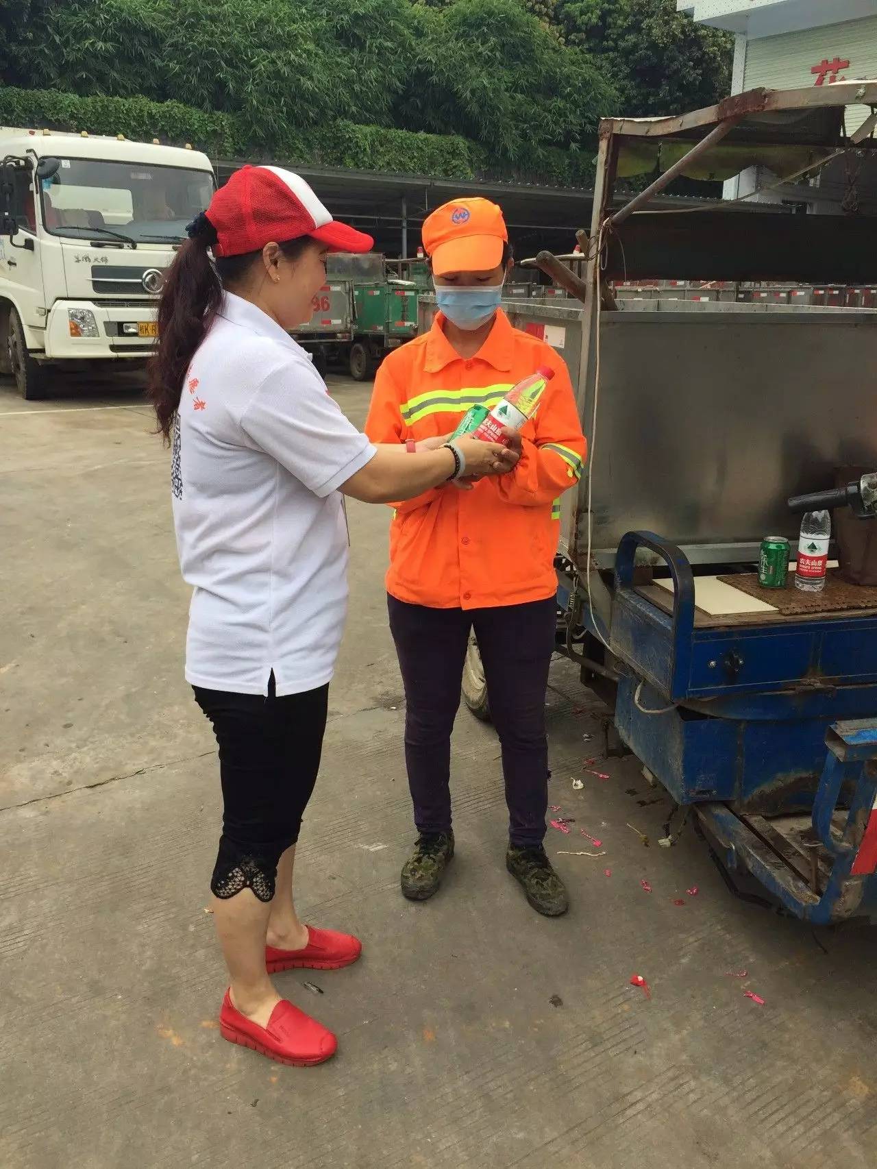 志愿者给环卫工人送饮用水