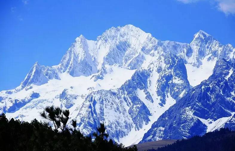 玉龙雪山:时而山顶云封 ,似乎深奥莫测;时而上下俱开,白云横腰一围