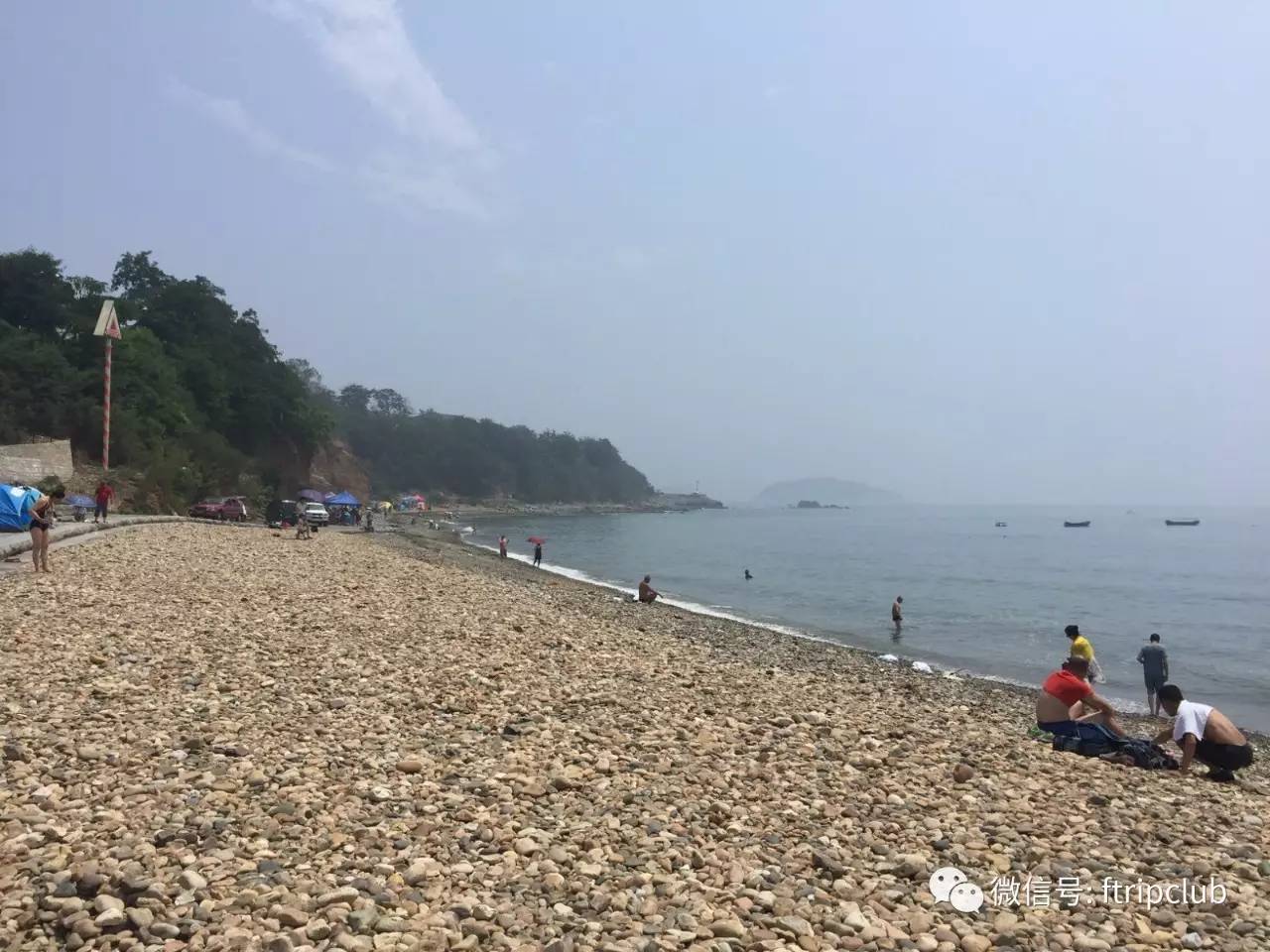 因为阴天,星海湾跨海大桥隐约的浮在眼前,孩子们依旧钟爱在沙滩挖沙子