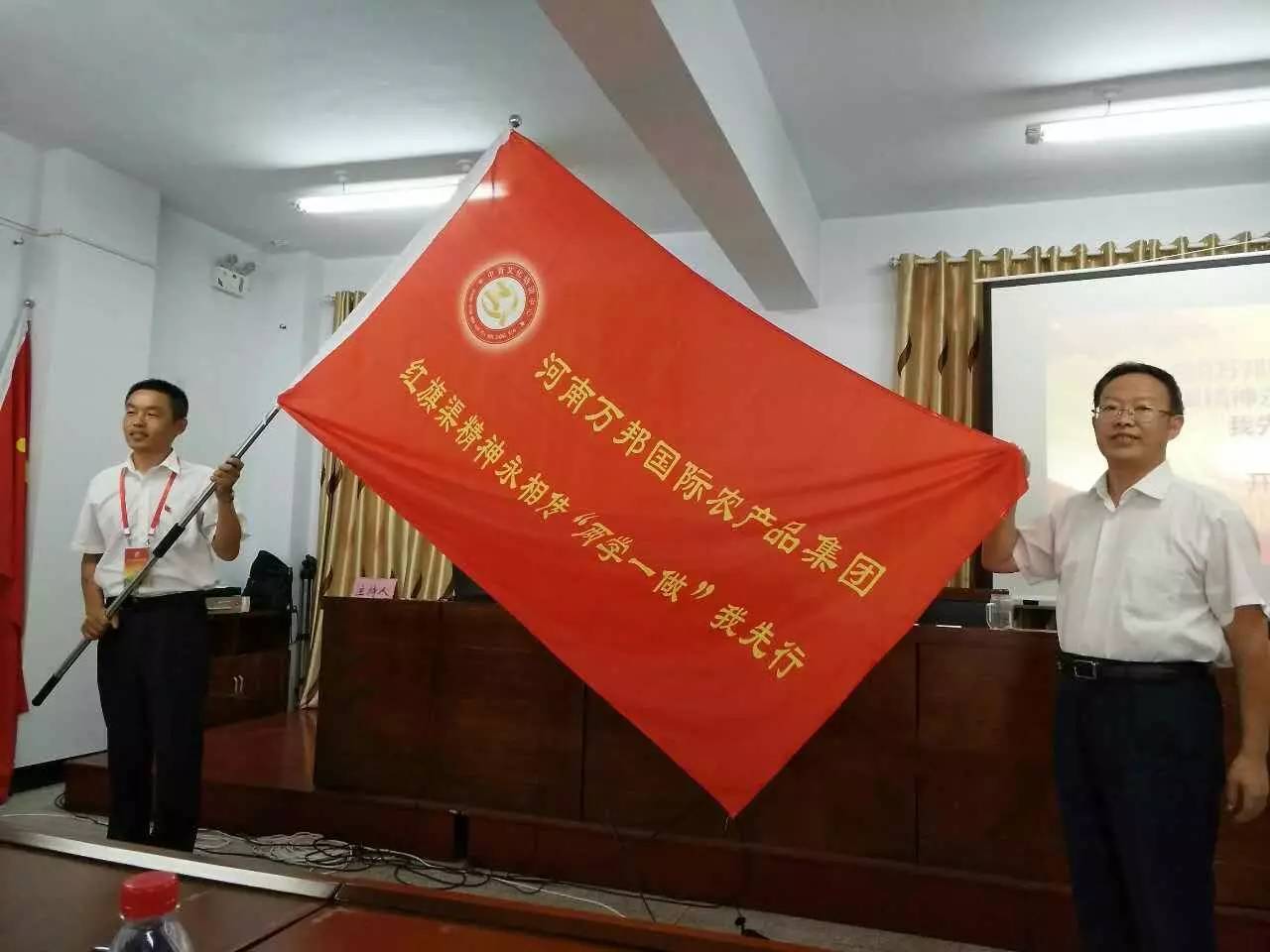 马校长为万邦集团授班旗,万邦党委委员,公司党支部书记王浩川同志接旗