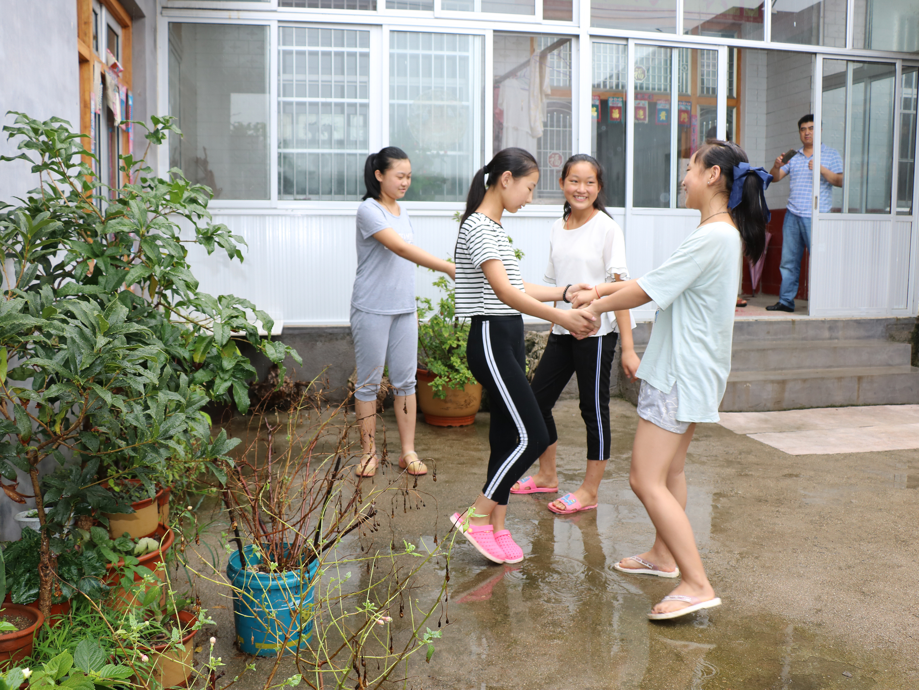 图二:8月3日,刚下过雨的院子里,郭玉娇和小伙伴们排练起自编的舞蹈