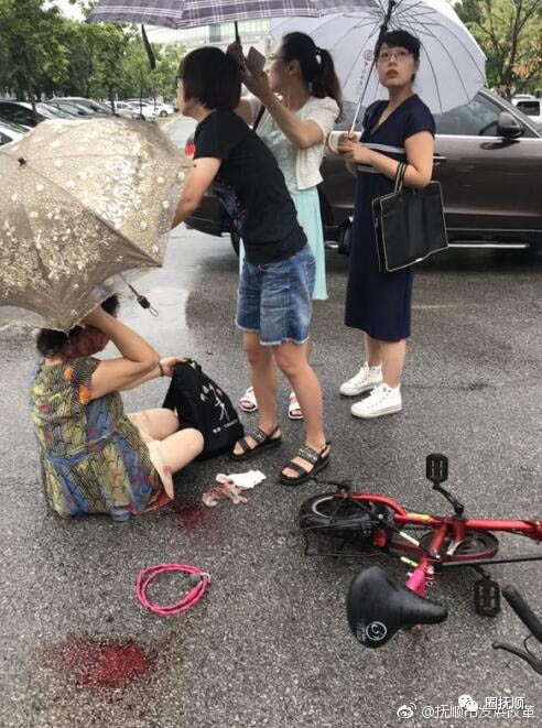 女子雨天骑车摔倒头部受伤抚顺四位公务员为她打伞叫来120