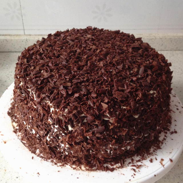 13,用刮刀把巧克力屑均匀的沾满蛋糕侧面,蛋糕表面也沾满巧克力屑