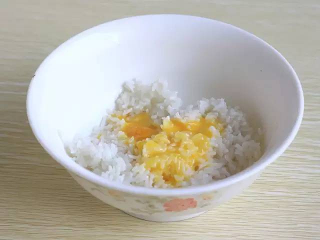 1.準備好熟米飯,將雞蛋黃分離出來,倒進米飯中