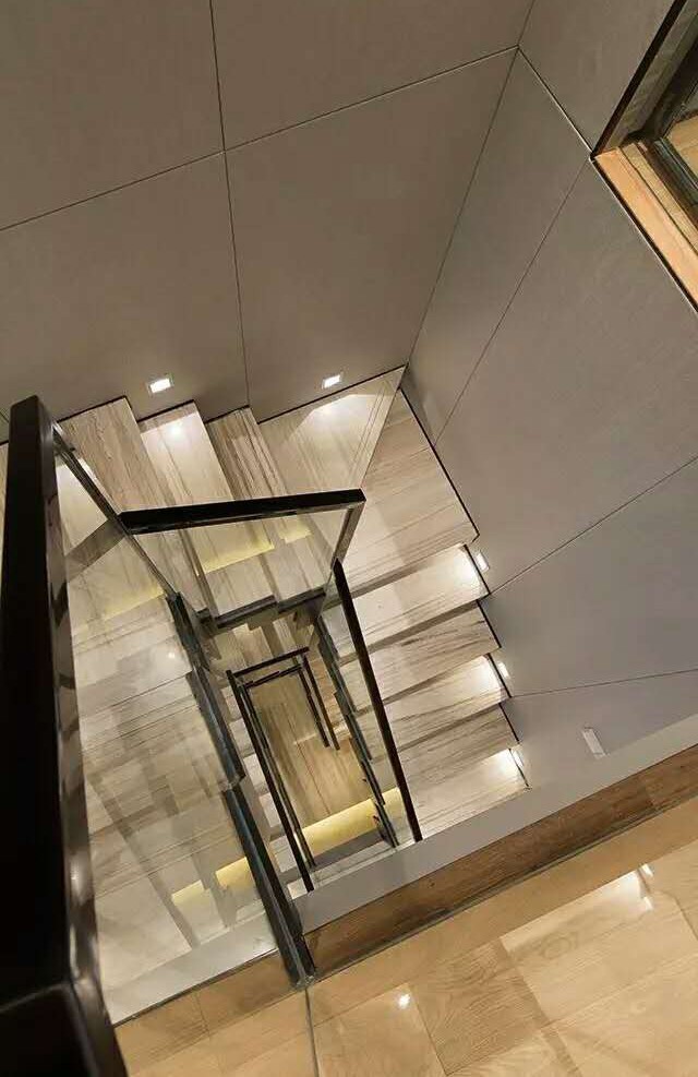 采用软包墙面的回型木质楼梯,让业主和宾客可以自然地进行垂直空间的