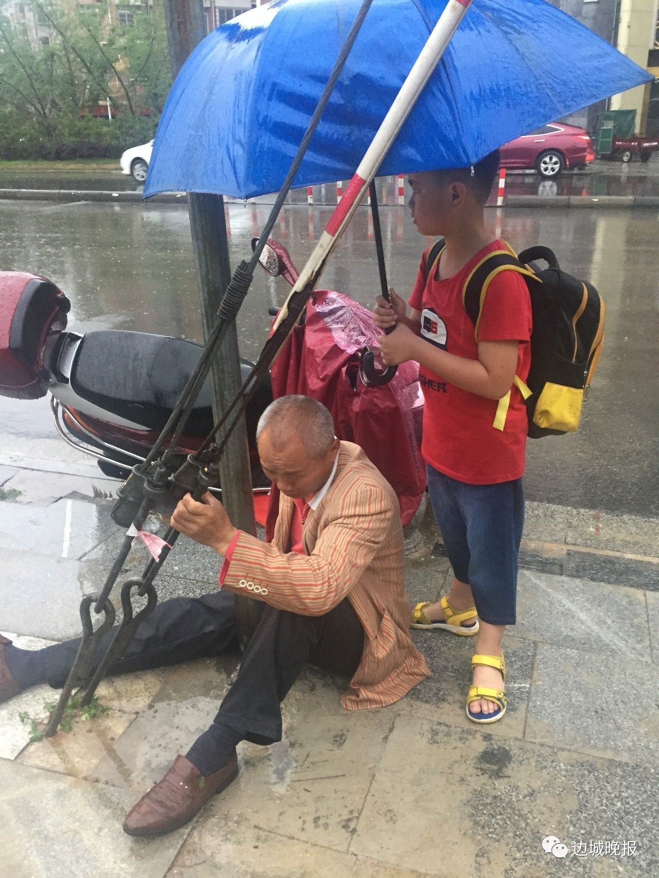 暴雨中 10岁男孩为受伤老人撑伞
