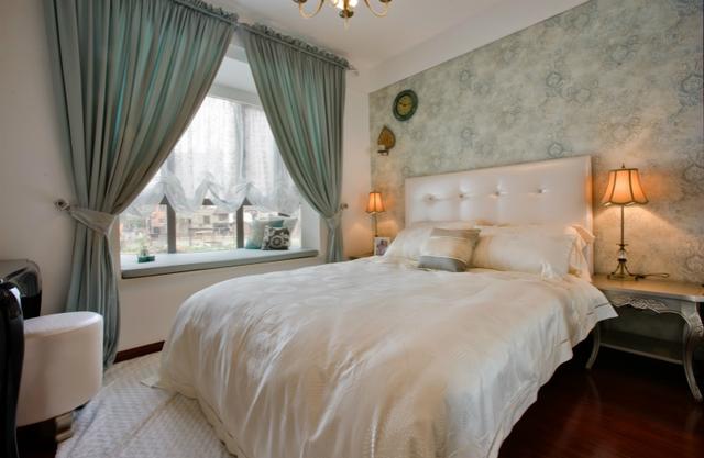 这是次卧,以绿色花纹的壁纸为床铺背景墙,搭配的窗帘也是绿色,飘窗被