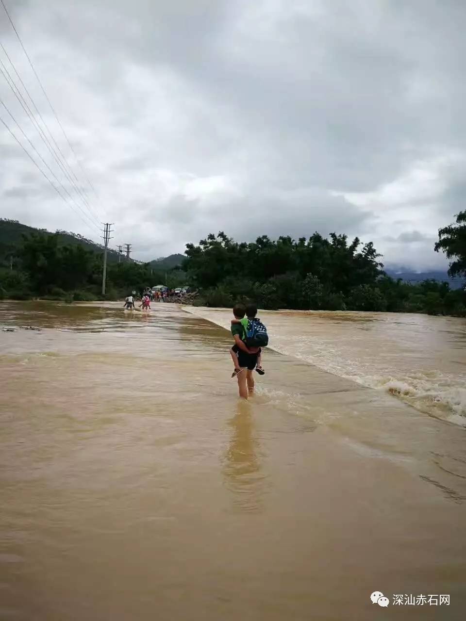 村桥被河水淹没老师自发背学生涉水过河看者暖心