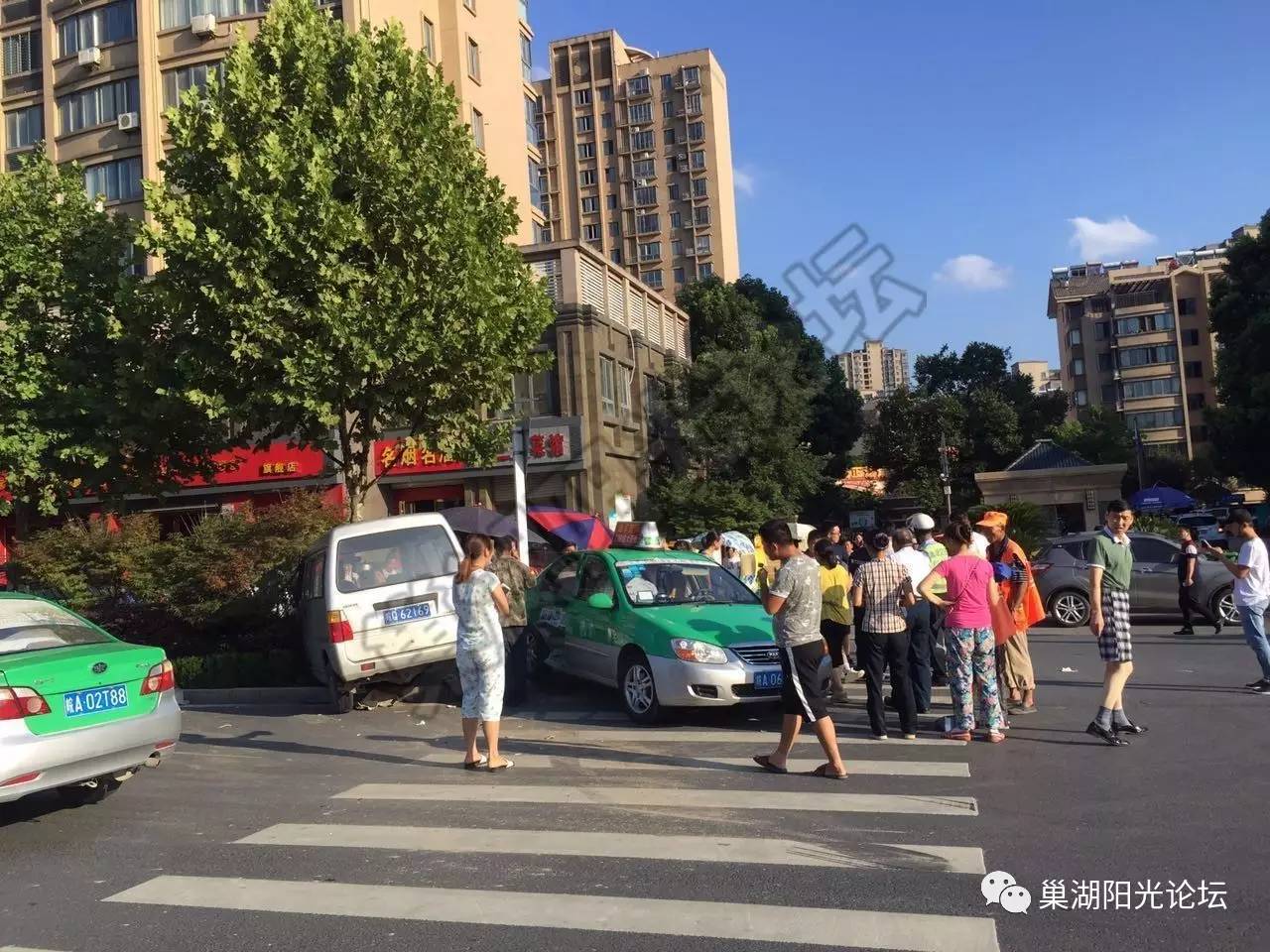 巢湖湖畔名郡门口发生一起车祸,面包车撞击出租车并冲上绿化带.