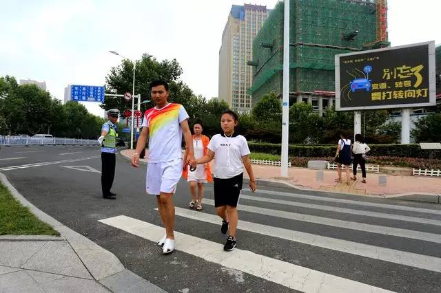 民警在各交通要道路口守護行人市民在民警的引導下走過斑馬線民警對行