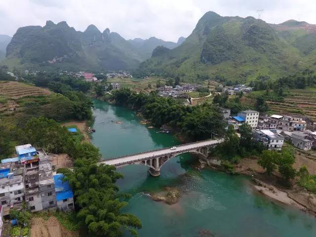 这是穿越都安瑶族自治县拉烈镇的刁江及两岸田园房舍(8月2日摄)