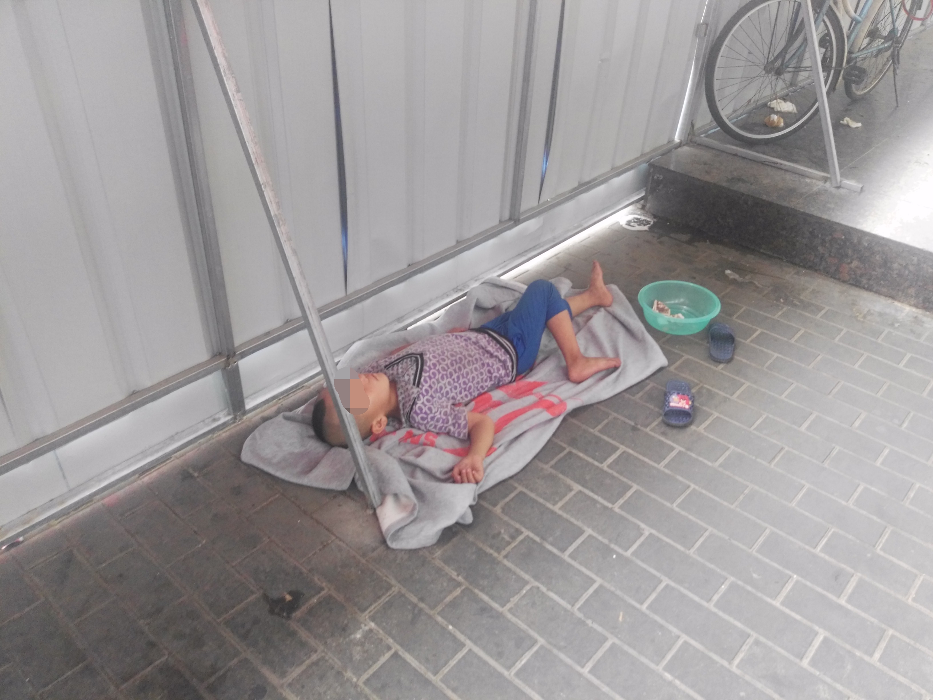 中山南路上一乞讨男子带着一个一直在睡觉的孩子